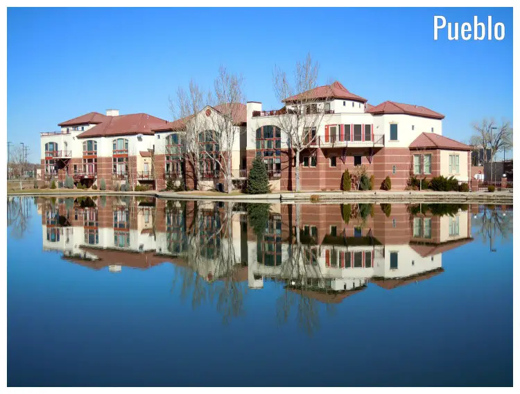 A scenic mirror image of a colorful red and white condo in Pueblo, Colorado