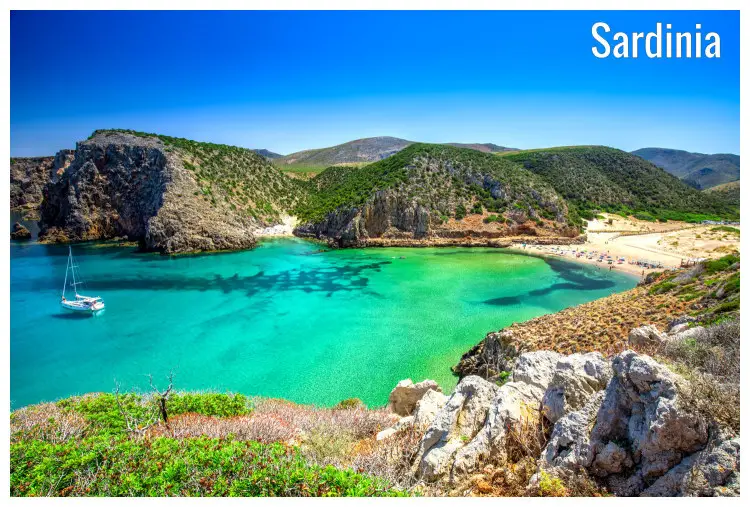 A single ship afloat on the clear waters of the stunning Cala Domestica beach in Sardinia Island, Italy A single ship afloat on the clear waters of the stunning Cala Domestica beach in Sardinia Island, Italy
